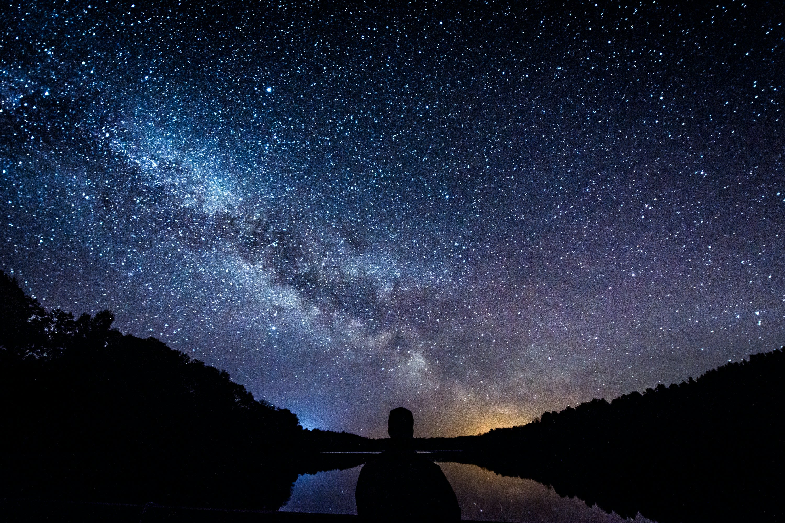 silhouette of person standing under starry sky