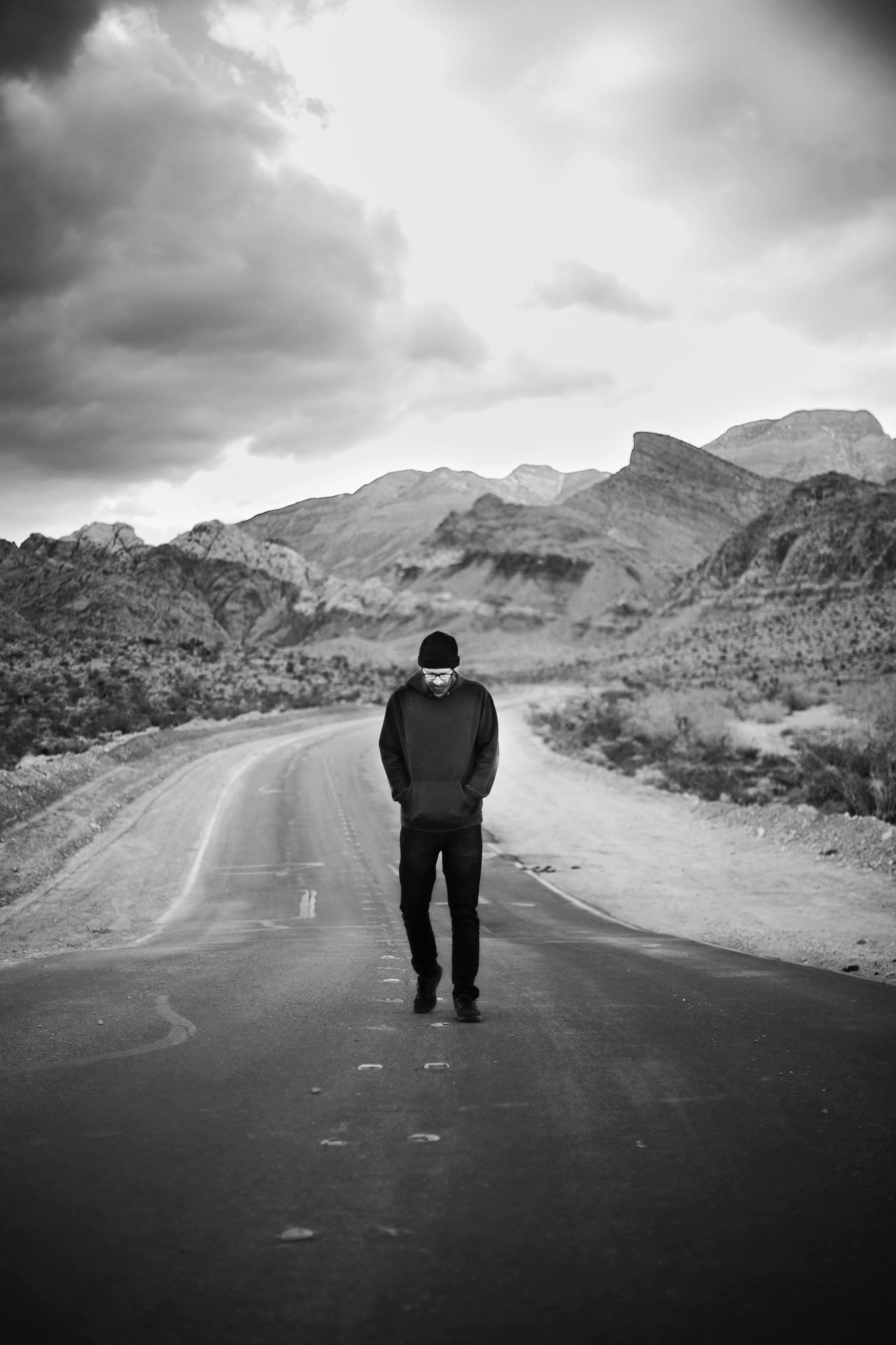 man in black jacket walking on road