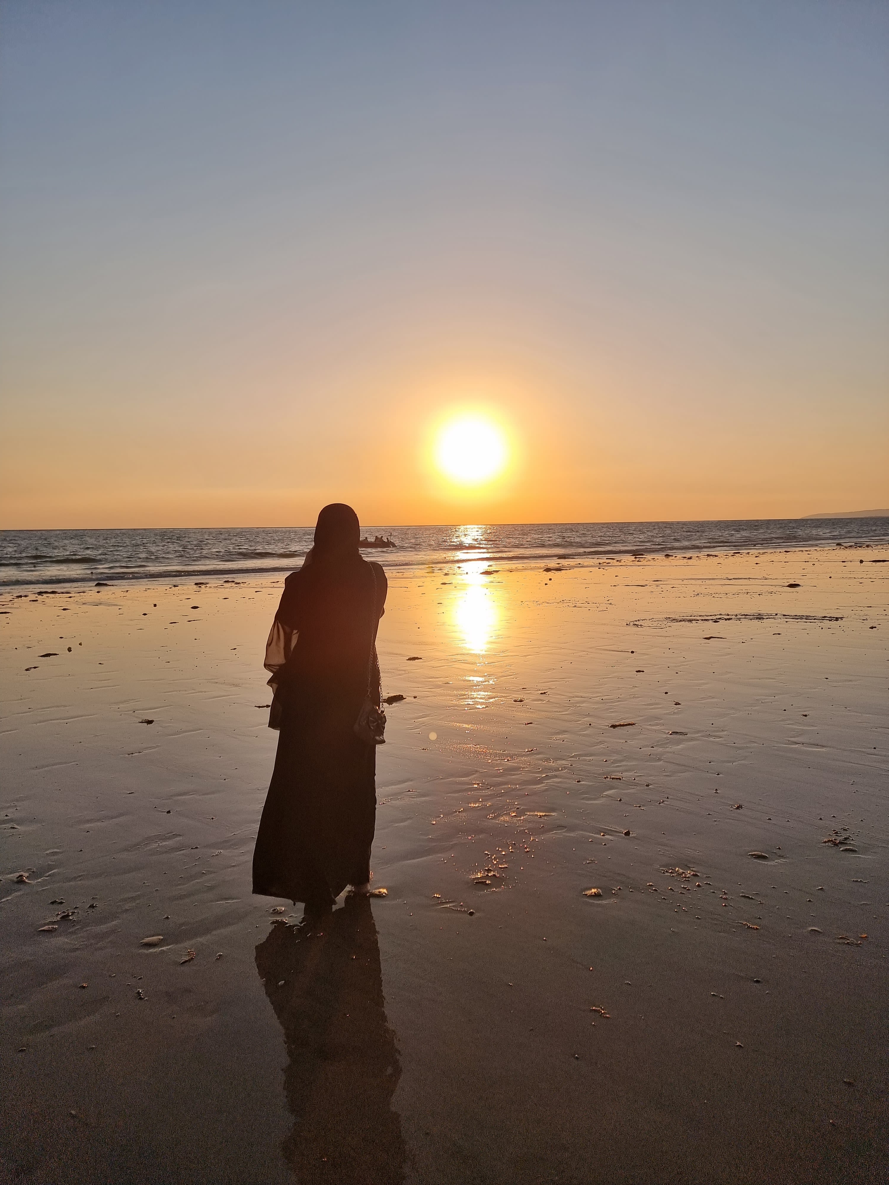 a woman standing on top of a beach next to the ocean